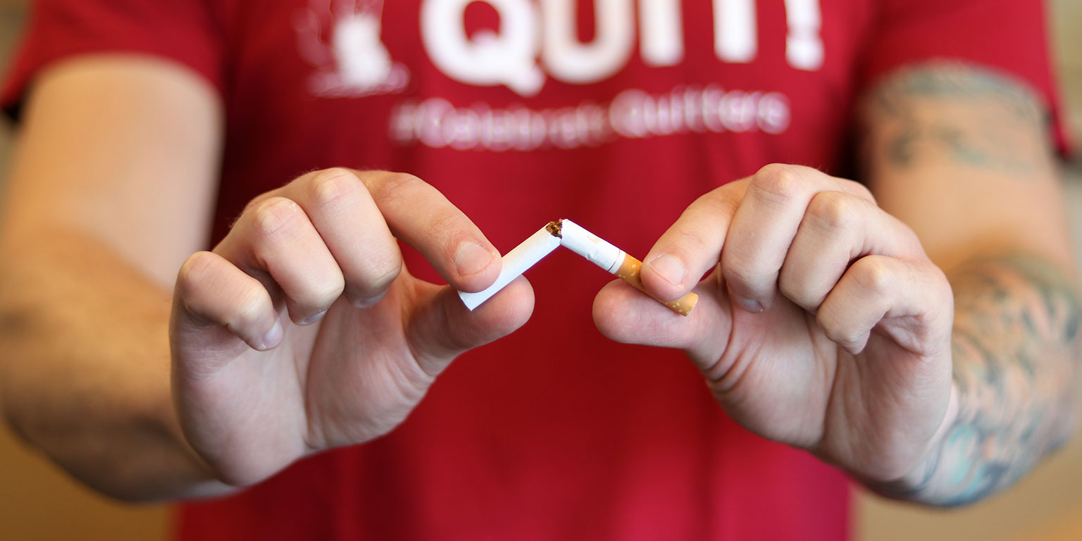 A close up of a cigarette being broken in half.